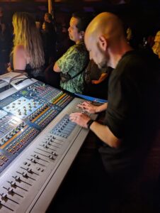 This image shows Rob Ruccia manning the mixing console for a live performance.