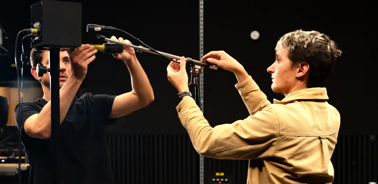 Two Slate Digital team members positioning a microphone in the studio